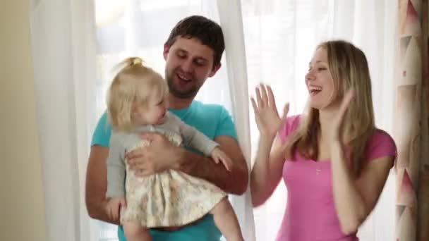 Familia feliz en casa. Mujer, hombre y niño en el fondo de la ventana . — Vídeos de Stock