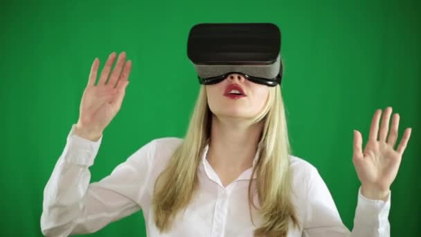 En kvinna i virtuella verklighets glasögon på en grön bakgrund — Stockvideo