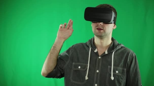 Un hombre con gafas de realidad virtual hace gestos con su mano . — Vídeos de Stock