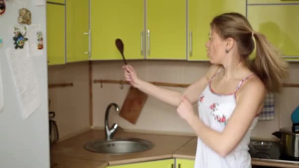 Jovem mulher feliz está dançando na cozinha . — Vídeo de Stock