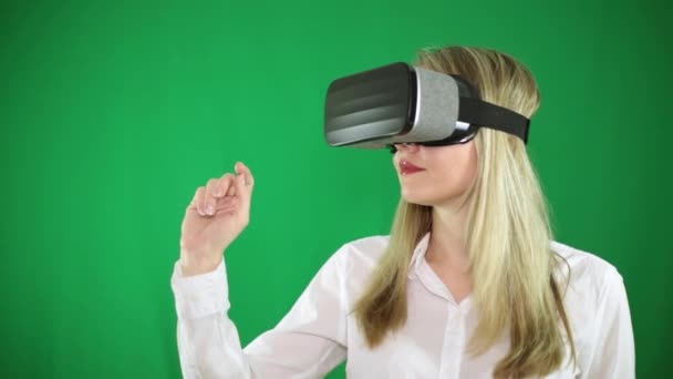 Een vrouw in virtual reality bril op een groene achtergrond. — Stockvideo