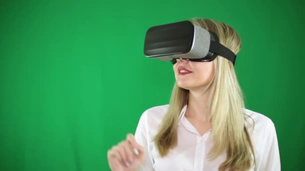 Uma mulher em óculos de realidade virtual faz movimentos com a mão . — Vídeo de Stock