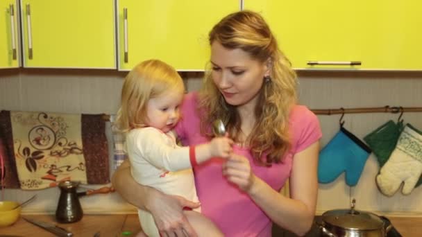 Mujer joven con bebé en la cocina — Vídeo de stock