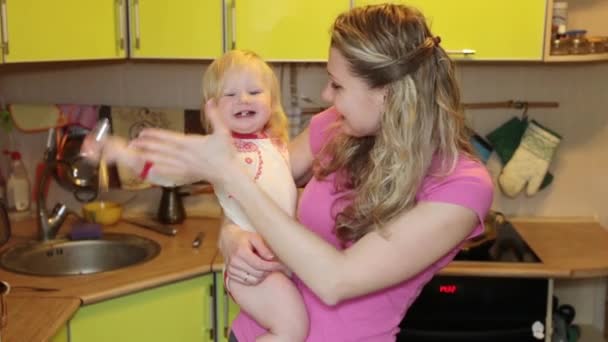 Žena s malým dítětem v kuchyni. — Stock video