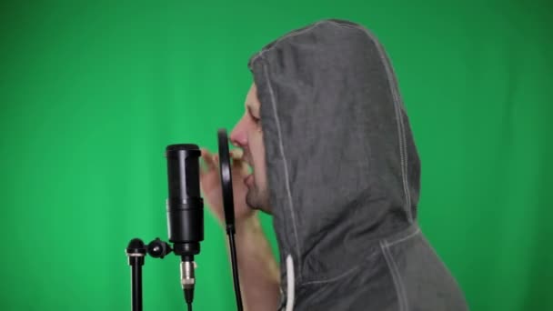 Чоловік в студії співає в мікрофон. Чоловік читає реп, хіп-хоп . — стокове відео