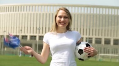 Avustralya bayrağı ile futbol fanatiği. Bir kadınla bir Avustralya bayrağı ve bir futbol topu.