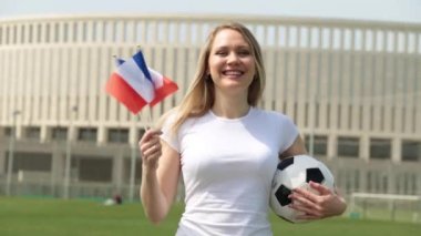 Fransa bayrağı ile futbol fanatiği. Bir Fransız bayrağı ve bir futbol topu kadın ile.