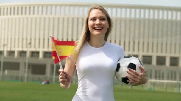 Tifoso di calcio con la bandiera spagnola. Donna con un pallone da calcio e la bandiera della Spagna . — Video Stock