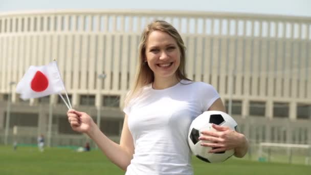 Fã de futebol com a bandeira do Japão. Mulher com bandeira japonesa e bola de futebol . — Vídeo de Stock