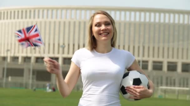 Fotbollsfan med flaggan i Storbritannien. Kvinna med en brittisk flagga och en fotboll. — Stockvideo
