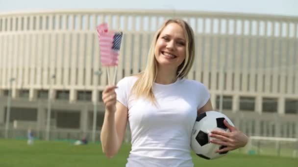 Abanico de fútbol con la bandera de Estados Unidos. Mujer con bandera americana y pelota de fútbol . — Vídeo de stock