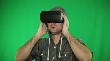 Bir kişi sanal gerçeklik gözlük kullanır. VR gözlük ve yeşil arka plan.