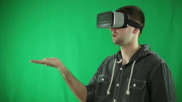 Een persoon in de virtual reality bril is bedrijf in zijn palm. — Stockvideo