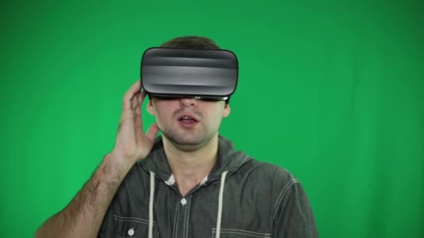 VR glasögon, grön bakgrund. En person i glas av virtuell verklighet. — Stockvideo