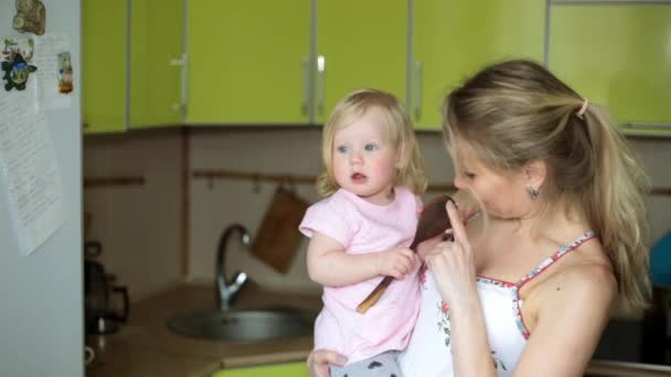 Una mujer con un niño pequeño en la cocina . — Vídeo de stock