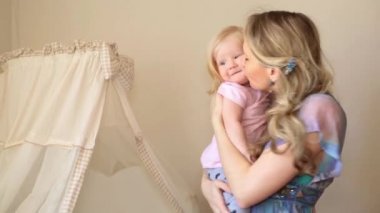 Bir kadın evde küçük bir çocuk tutuyor.