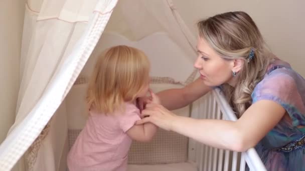 Una donna sta giocando con il suo bambino in camera da letto . — Video Stock