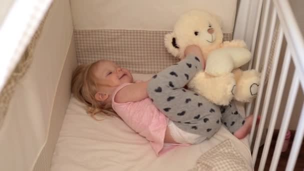 Child is playing with a teddy bear in the bedroom. — Stock Video