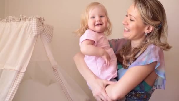 Una mujer en la guardería sostiene a un niño pequeño. Mamá y bebé, feliz maternidad . — Vídeos de Stock