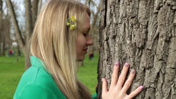 Nature and harmony. A young woman touches a tree. — Stock Video
