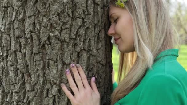 Pihenés, nyugalom, egység a természettel és a harmónia. Egy fiatal nő megérinti egy fa. — Stock videók