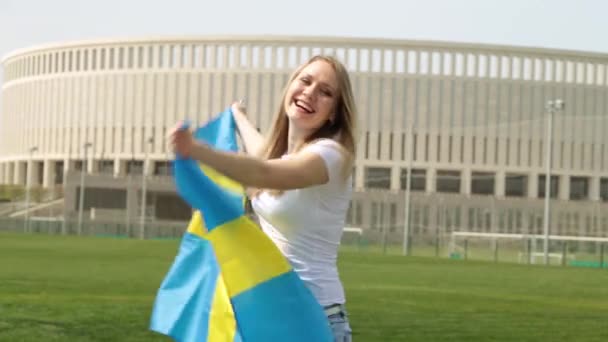 Kvinde med Sveriges flag. Kvinde sportslige en fan med flag Sverige . – Stock-video