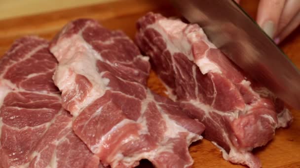 Una mujer está cortando carne en la cocina, de cerca. Carne cruda, filetes . — Vídeos de Stock