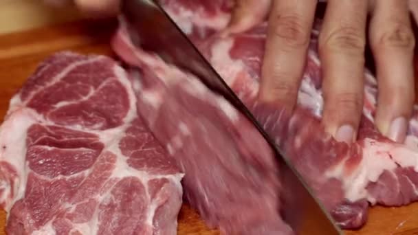 Ein Mann schneidet in der Küche Fleisch in Großaufnahme. rohes Fleisch, Steaks.
