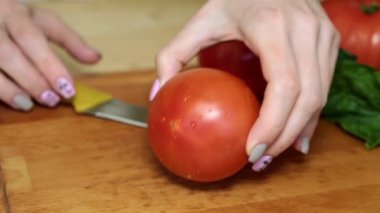 Mutfakta domates kesme bir kadındır.