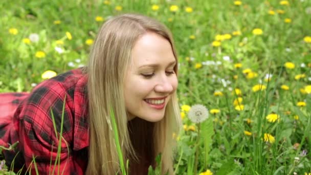 Young woman blowing on a dandelion. — Stock Video