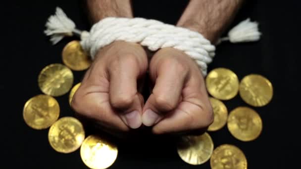 Bitcoins und gebundene Hände einer Person. Finanzsklaverei, Aufregung, Schulden. — Stockvideo