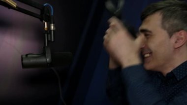 Bir Dj adam radyolar Studio bir mikrofona konuşur.