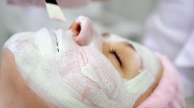 Güzellik salonunda krem maskeli bir kadın, yakın plan. Kozmetoloji, yüz bakımı.