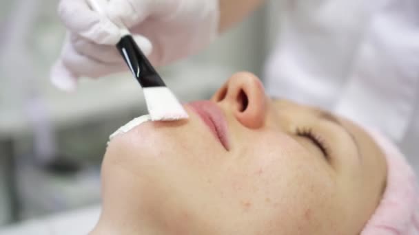 Beautician applies face cream on a womans skin, close-up. — Stock Video