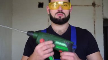 Elektrikli bir aletle erkek müteahhit portresi.