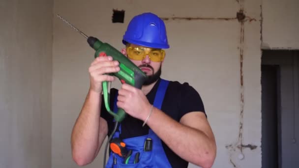 Un trabajador de la construcción está bailando con un martillo eléctrico en la mano. . — Vídeos de Stock