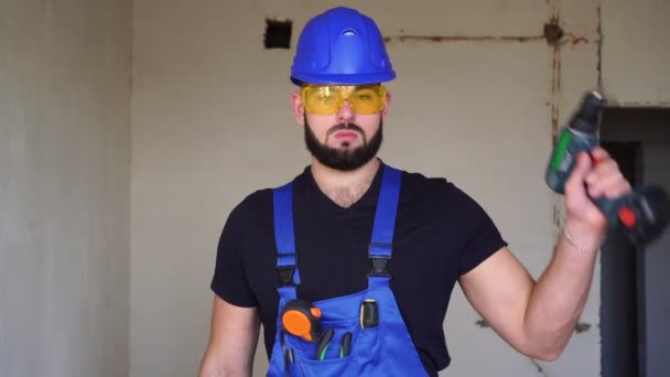Porträtt av en manlig byggare med en elektrisk skruvmejsel. — Stockvideo
