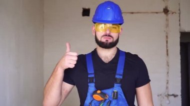 Erkek müteahhit baş parmağını gösteriyor..