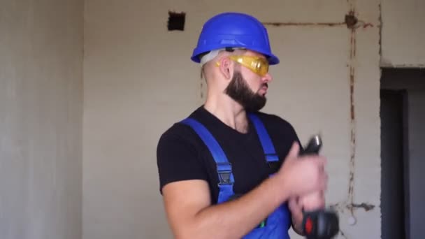 Constructor masculino sexy positivo bailando con un destornillador eléctrico . — Vídeo de stock