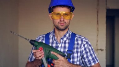 Elektrikli çekiçli genç bir inşaat işçisi..