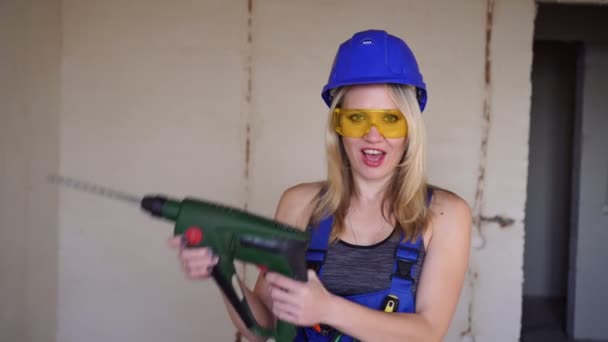 Young sexy female builder with an electric tool. Portrait of a builder woman. — Stock Video