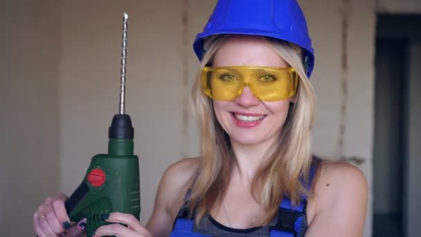 Hermosa mujer rubia constructora con un martillo eléctrico punzón . — Vídeos de Stock