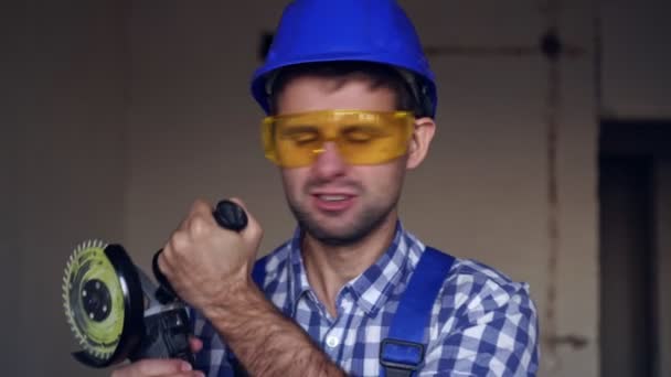 Porträtt av en känslomässigt glad byggare hane med elektriska byggverktyg. — Stockvideo