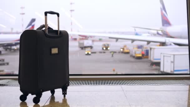 Aeroporto, sala de espera, sem pessoas. Mala no fundo dos aviões — Vídeo de Stock