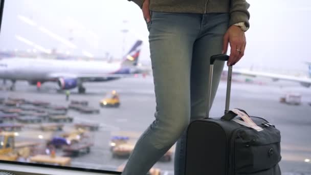 Vrouw toerist met een koffer op de luchthaven wachtend op instappen in een vliegtuig — Stockvideo