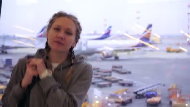 Portrait of a woman at the airport on the background of airplanes — Stock Video