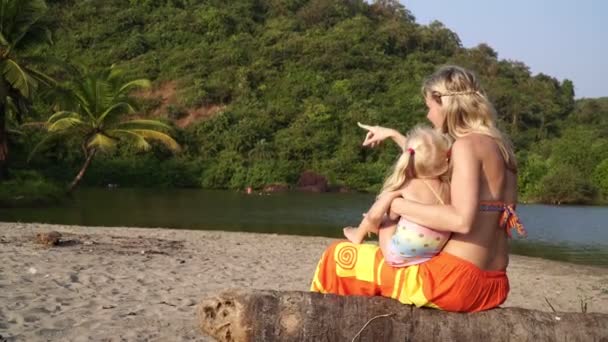 Woman with a child on the background of a tropical lake. Goa, Sweet Lake, Arambol. — Stok video