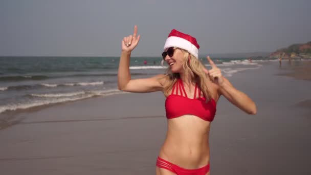 Kerstmis en Nieuwjaar op het strand. mooie vrouw dansen door de zee — Stockvideo