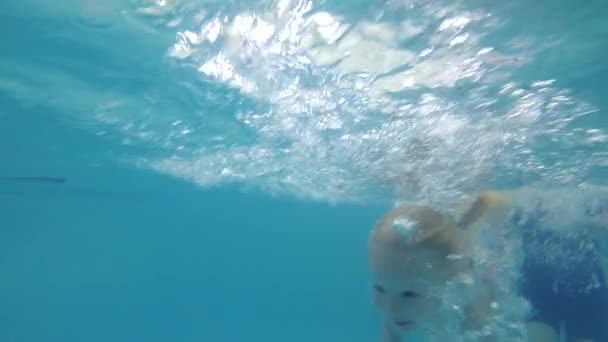 Un petit enfant apprend à nager dans la piscine. L'enfant nage sous l'eau — Video