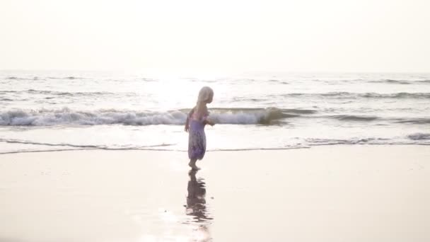 Menina criança pulando e dançando na praia do mar. Movimento lento — Vídeo de Stock